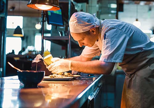 Chef serving food in the modern kitchen in a high-end restaurant