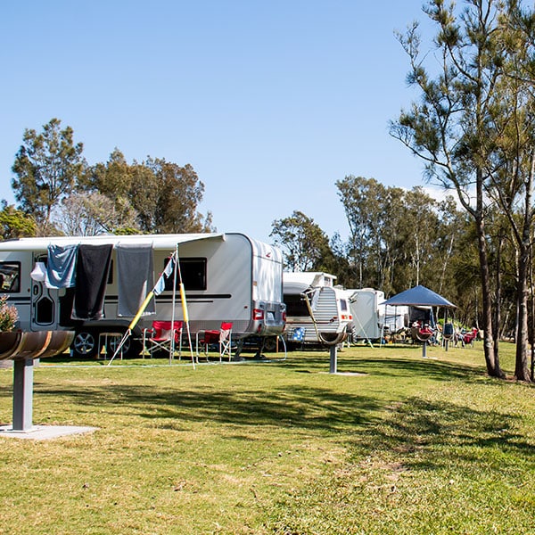 RV caravans camping at the caravan park on the lake with mountains on the horizon. Camping vacation travel concept